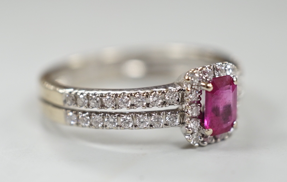 A modern 18ct white gold, single stone emerald cut ruby and diamond chip set cluster ring, with two row diamond chip set shoulders, size K, gross weight 3.3 grams.